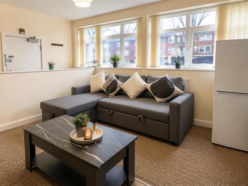 a living room with a couch and a table at Premium 2BR Retreat for Long Stays in Manchester