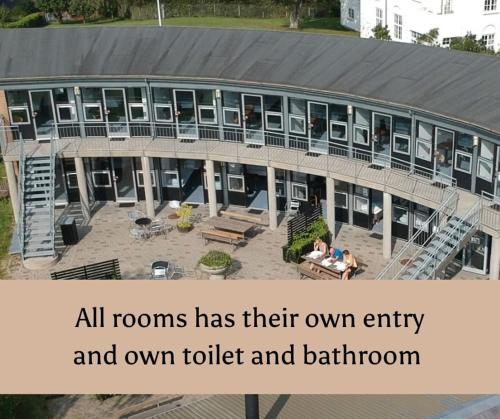 an image of a building with the words all rooms has their own entry and own at Danhostel Rønde in Rønde