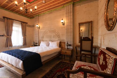 a bedroom with a bed and a chair and a mirror at Hasan Bey Konakları in Avanos