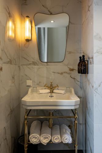 a bathroom with a sink and a mirror and towels at ADAM & EVE Paleisstraat in The Hague