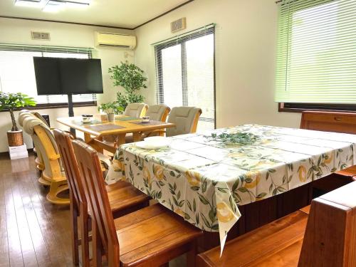 a dining room with a table and a table and chairs at ビレッジ幸 in Otsu