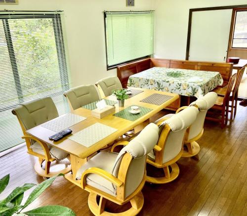 a dining room with a wooden table and chairs at ビレッジ幸 in Otsu