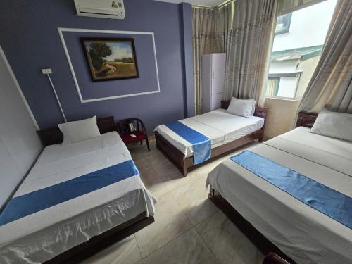 a hotel room with two beds and a window at Gia An Hotel in Hanoi