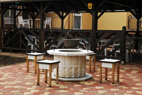 ハイドゥソボスローにあるGarden Apartmanház 2のテーブルの横に2脚のスツールが並ぶ噴水