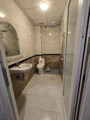 a bathroom with a shower and a toilet and a sink at Gia An Hotel in Hanoi