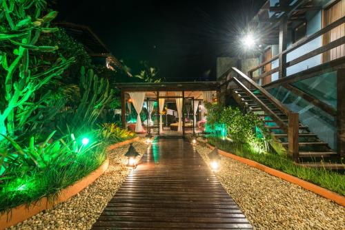 a walkway in front of a building at night at La Pedrera Small Hotel & Spa in Búzios