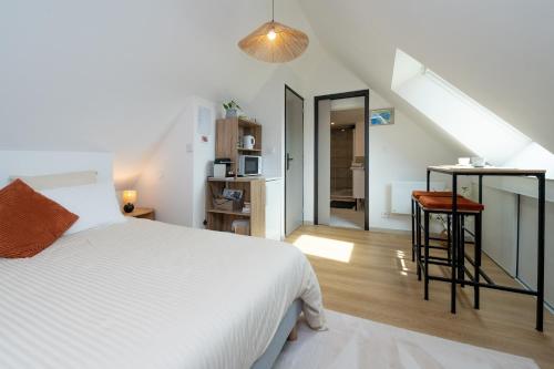 a bedroom with a white bed and a staircase at Chambre d'hôtes reflets du Golfe in Arradon