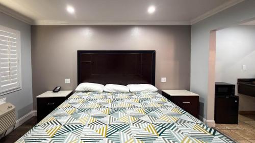 a bedroom with a large bed with a colorful comforter at Studio 6 Oakland CA San Francisco Berkeley Area in Oakland