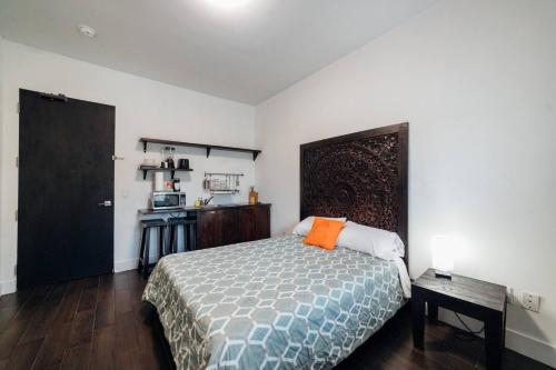 a bedroom with a bed with an orange pillow on it at Vive Zen Queen Room in Miami