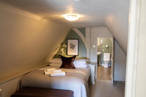a room with a bed with towels on it at The Woolpack Hotel in Tenterden