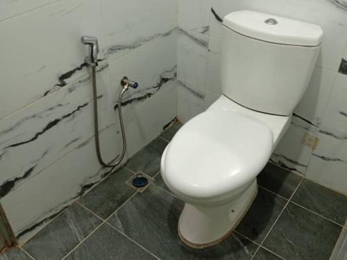 a bathroom with a white toilet and a shower at Hijrah De La Villa Parit Buntar Nibong Tebal Penang in Nibung Tebal
