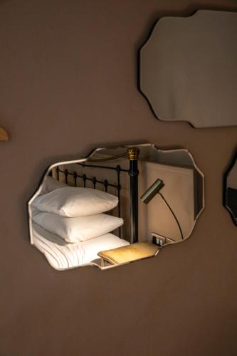 a mirror hanging on a wall with pillows at The Woolpack Hotel in Tenterden