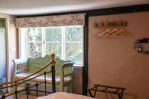 a bedroom with a window and a crib in a room at The Woolpack Hotel in Tenterden