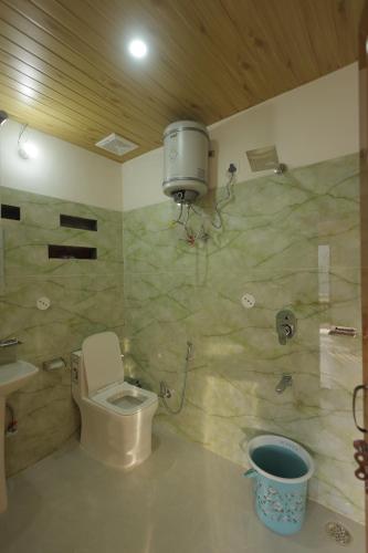 a bathroom with a toilet and a shower and a sink at Ransuli mountain retreat in Dehradun