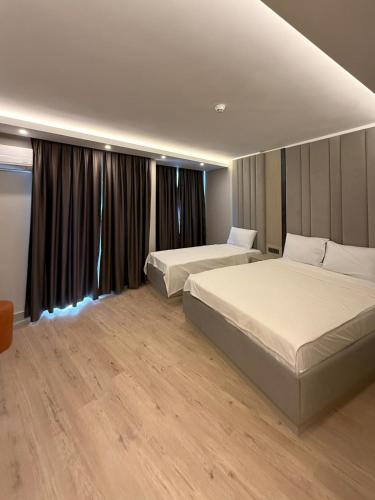ein Hotelzimmer mit zwei Betten und einem Fenster in der Unterkunft Kayalar Hotel in Antalya