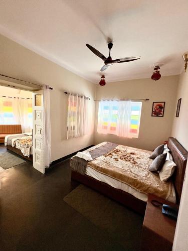 a bedroom with two beds and a ceiling fan at L2 Darbar Kothi Heritage Living in Jodhpur