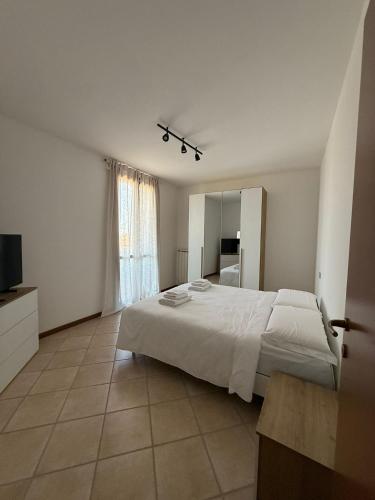 a bedroom with a large white bed and a mirror at Country Escape in Poggio Renatico