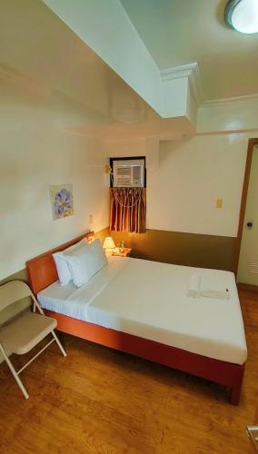 a bedroom with a large bed and a chair at ZKB Twins Hotel in General Santos