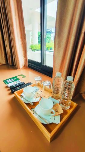 a tray with cups and dishes on a table next to a window at ZKB Twins Hotel in General Santos