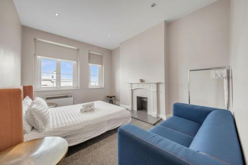 a bedroom with a bed and a blue couch at Heart of Shoreditch in London