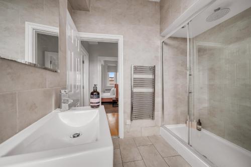 a bathroom with a tub and a sink and a shower at Heart of Shoreditch in London