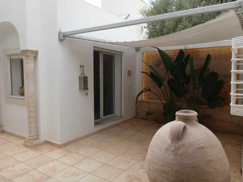 a large vase sitting on a patio with a plant at Lucky Day in La Marsa