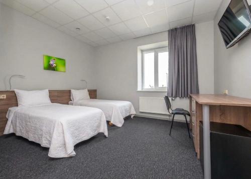 a hotel room with two beds and a television at Air Kaunas in Karmėlava