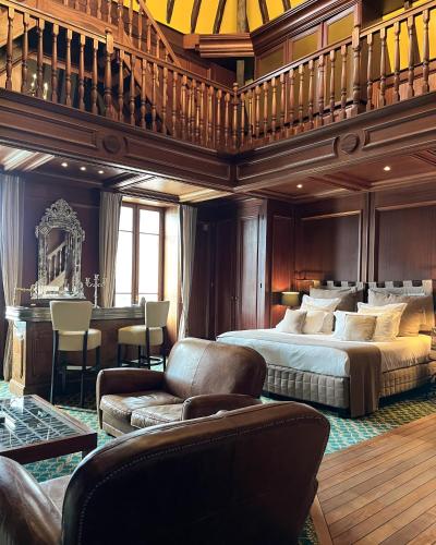 a large bedroom with a bed and a piano at Le Palace de Menthon in Menthon-Saint-Bernard