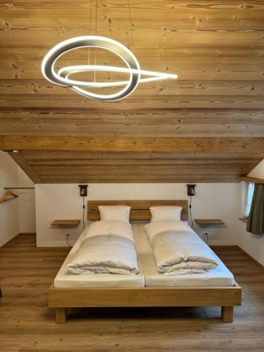 two beds in a room with a wooden ceiling at Hotel Altels in Kandergrund