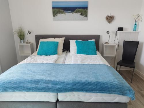a bedroom with a bed with blue and white sheets at Ferienwohnung mit Meerblick, 2 Schlafzi, Box- Bett, Süd- Balkon, eig, Parkplatz, Glasfaser in Dahme