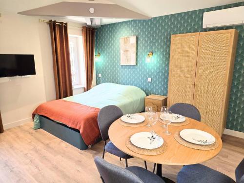 a hotel room with a bed and a table and chairs at Le Nid Douillet Studio in Saint-Affrique