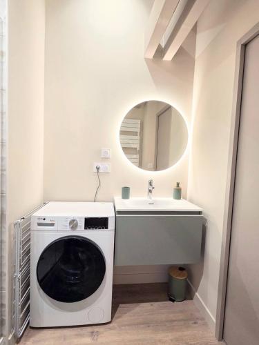 a bathroom with a washing machine and a sink at Le Nid Douillet Studio in Saint-Affrique