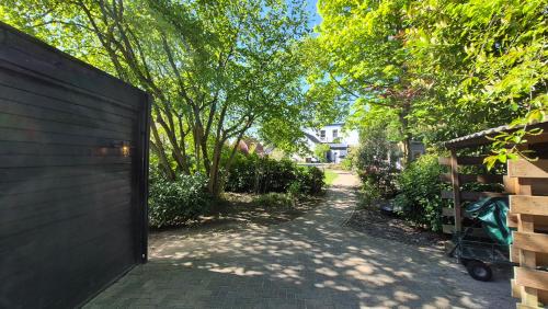 Eine Auffahrt führt zu einem Haus mit Zaun und Bäumen. in der Unterkunft De Kansel in Nieuw-Dordrecht