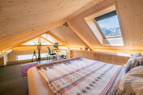 a bedroom with a large bed in a attic at Tiny Bishorn mit privatem Whirlpool in Grächen