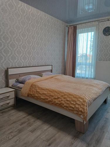 a bedroom with a bed and a window at Апартаменти в ЦЕНТРІ ІМПЕРІАЛ in Truskavets