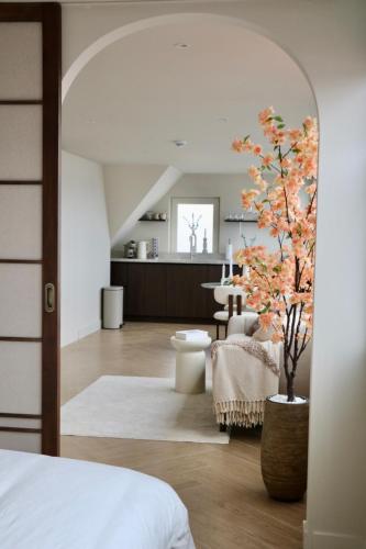 a bedroom with a bed and a tree in a room at Breeze Inn B&B in Oegstgeest