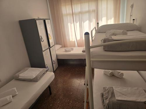 a room with three bunk beds and a window at Albergue La Corona1 in O Pino 