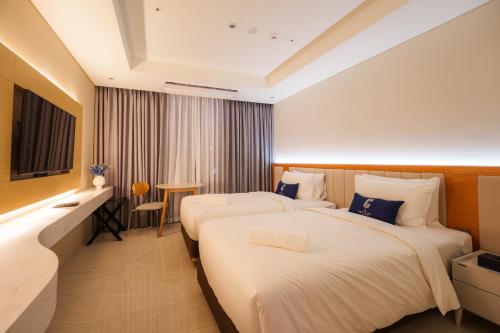 a hotel room with two beds and a television at The First Clark Hotel and Residence in Pampang