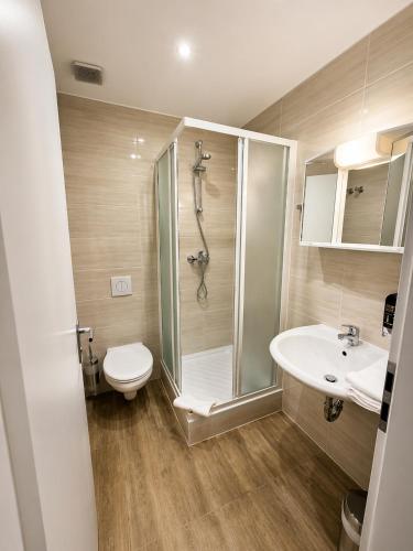 a bathroom with a shower and a toilet and a sink at Hotel Post Nürtingen in Nürtingen