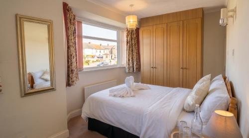a bedroom with a bed with a mirror and a window at Tharsh Peaceful Escape Double Room with Shared Bathroom in Coundon