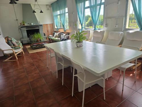 a dining room with a white table and chairs at Albergue La Corona1 in O Pino 