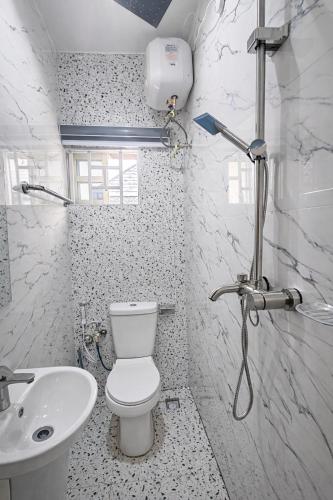 a white bathroom with a toilet and a sink at The Whale Inn Narayi rd Barnawa high cost in Kaduna