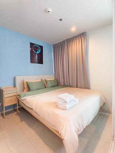 a bedroom with a large bed with towels on it at BLU Diamond Cha Am in Ban Bo Khaem