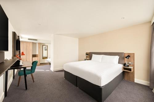 a hotel room with a bed and a desk at Holiday Inn Birmingham City by IHG in Birmingham