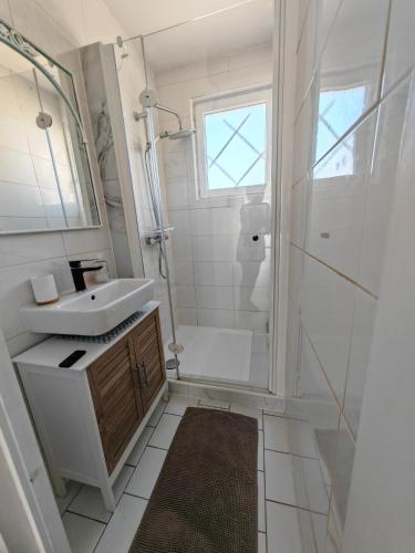 a white bathroom with a sink and a shower at Le MABILEAU in Saumur