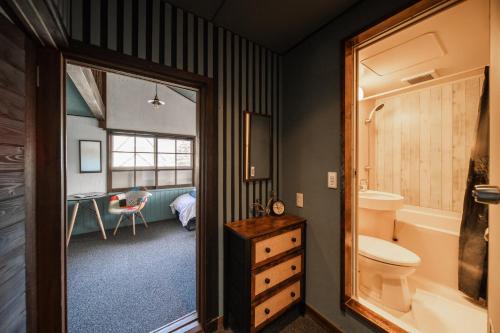 a bathroom with a sink and a toilet and a desk at The Bears Lodge in Hakuba