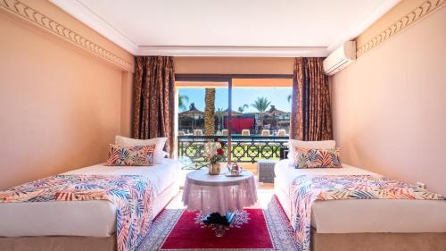 two beds in a room with a window at Club Paradisio in Marrakesh