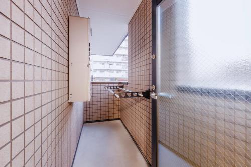 a corridor of a bathroom with a door open at Anecis笠取町2 in Nagoya