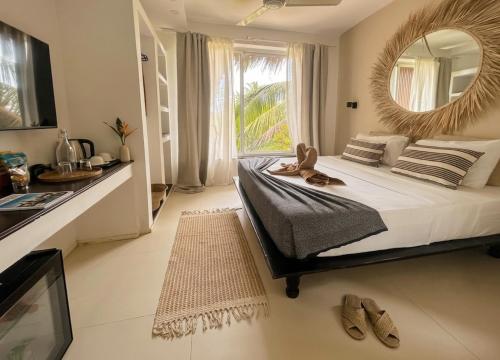 a bedroom with a bed with a mirror and a sink at Kuwa Zanzibar in Kiwengwa