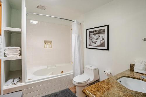 a white bathroom with a tub and a toilet and a sink at Malibu Beachfront Home with Rock Spa Ocean Views & Huge Deck in Malibu